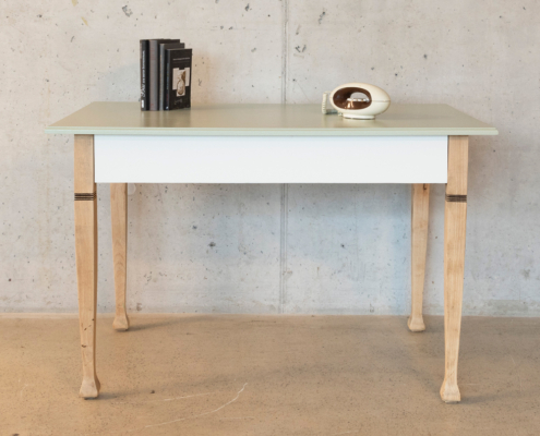 Holztisch mit pastellgruener Arbeitsplatte